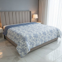 Bed with floral comforter in a modern bedroom setting
