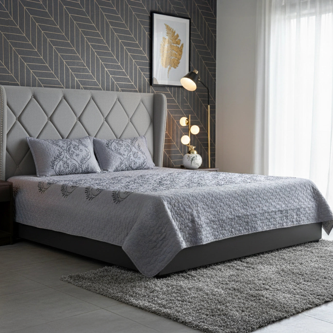 Gray upholstered bed with matching bedding in a modern bedroom setting.