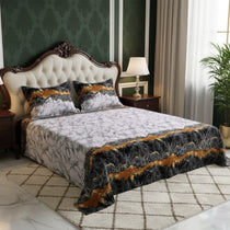 Decorative bedspread with gold and black patterns on a bed in a stylish bedroom.