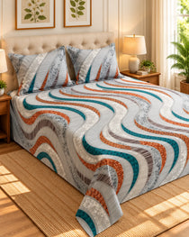 A bed dressed in a quilted bedding set with a wavy striped pattern in teal, rust orange, gray, and white, styled in a bright, modern bedroom with wooden nightstands, lamps, and a woven rug.